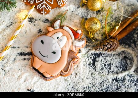 Délicieux pain d'épice parfumé sous forme de taureau et de flocons de neige, symbole de la nouvelle année. Bâtons de cannelle, boules de Noël dorées pour la Christm Banque D'Images