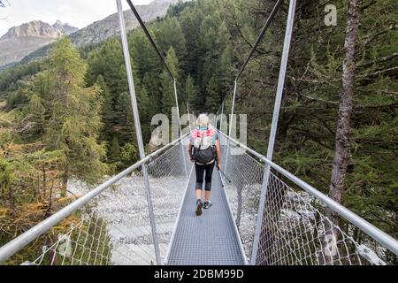 Vue de la femme marchant sur le pont, Valais, Suisse Banque D'Images