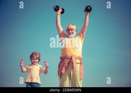 Sportif grand-père et enfant en bonne santé avec exercice de haltères. Santé mode de vie joyeux. Concepts de sport et d'entraînement. Sport familial. Suivez Banque D'Images