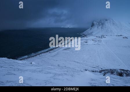 Nuages sombres d'hiver sur le village côtier de Myrland pendant la nuit polaire de décembre, Flakstadøy, îles Lofoten, Norvège Banque D'Images