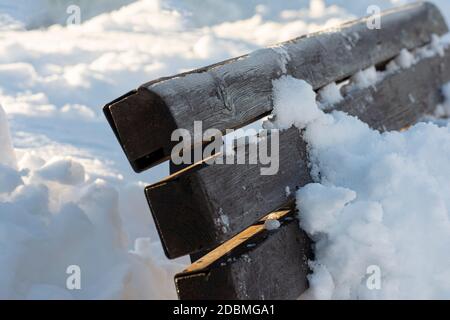 Banc en bois recouvert de neige en plein air après une forte chute de neige Banque D'Images