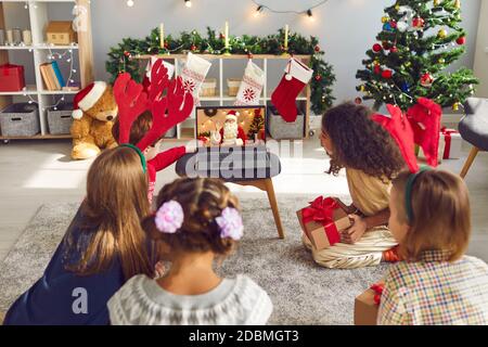 Un groupe d'enfants se réunit autour d'un PC portable et d'un père Noël avec appels vidéo Claus le remercie de ses cadeaux Banque D'Images