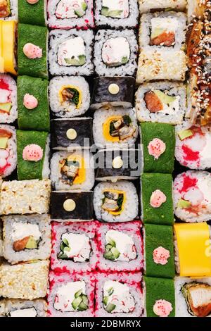 Cuisine japonaise à sushis. Maki pads avec thon, saumon, crevettes, crabe et avocat. Vue sur les sushis assortis. Rouleau de sushi Rainbow, uramaki, hosomaki an Banque D'Images