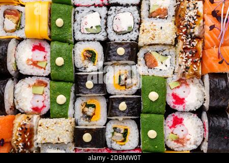 Assortiment de sushis sur fond de pierre. Un jeu énorme de rouleaux de couleur avec différents farce. Saumon, thon, anguille, avocat, concombre, fromage de Philadelphie, Banque D'Images