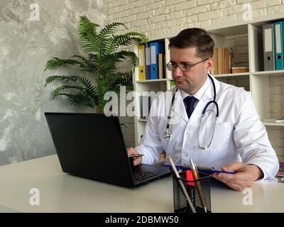 Concept de télémédecine. Un médecin travaille avec un ordinateur portable. Banque D'Images