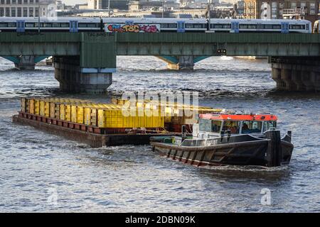 Barges remorquées par un bateau à remorqueurs sur la Tamise, Londres Angleterre Royaume-Uni Banque D'Images