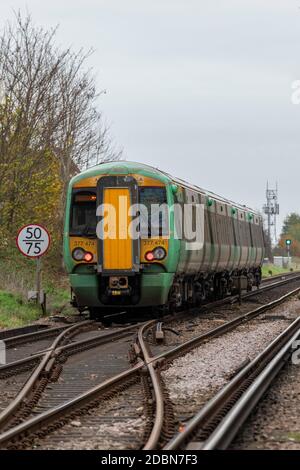 un service ferroviaire du sud qui passe par un ensemble de points sur les voies ou les lignes qui passent par un panneau de restriction de vitesse. Banque D'Images