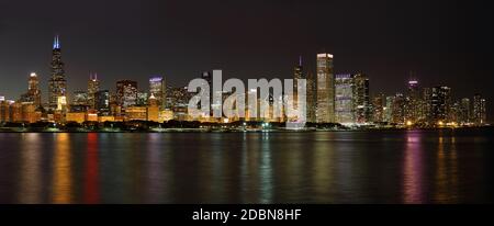 Vue sur Chicago et front de mer la nuit avec bâtiments éclairés Se reflète dans l'eau du lac Michigan Banque D'Images