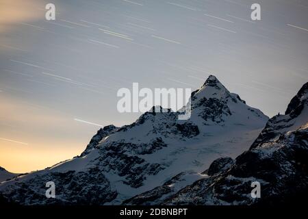 Des pistes étoiles au-dessus du mont Matier tandis que la lune illumine la montagne lors d'une soirée d'automne en Colombie-Britannique. Banque D'Images