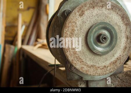 Ancienne meuleuse de pierre à affûter rouillée dans l'atelier Banque D'Images