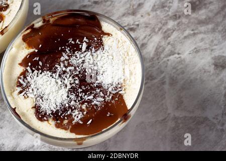 Tarte cétogène hollandaise recouverte de noix de coco râpée et de chocolat servi dans un bol individuel. Banque D'Images