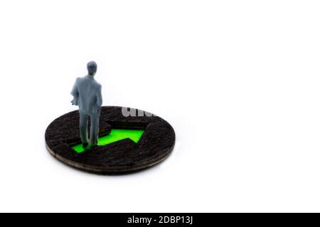 Figurine miniature posée comme représentant un homme d'affaires debout sur une flèche verte marquant la voie à suivre, minimaliste image conceptuelle abstraite avec cop Banque D'Images