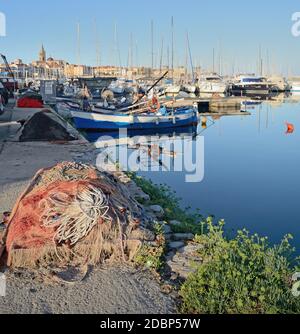 un aperçu du port peu après l'aube avec le filets de pêcheurs sur le quai et la ville dans le arrière-plan Banque D'Images