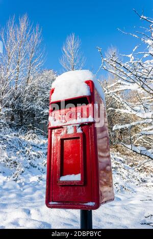 Boîte postale britannique rouge traditionnelle recouverte de neige fraîche Banque D'Images