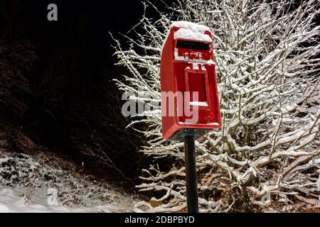 Boîte postale britannique rouge traditionnelle recouverte de neige fraîche Banque D'Images