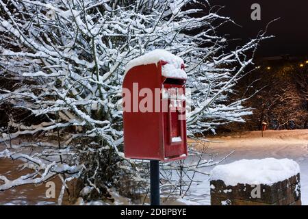 Boîte postale britannique rouge traditionnelle recouverte de neige fraîche Banque D'Images