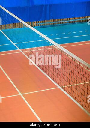 Salle de gym moderne vide avec filet de volley, cadre vertical. Banque D'Images