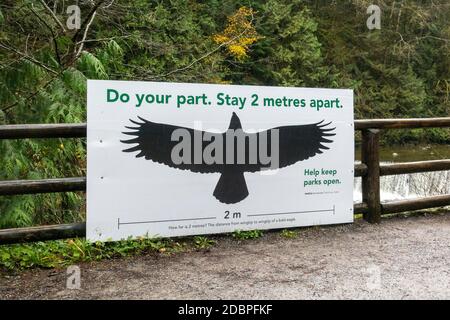 Restez à 2 mètres l'un de l'autre, un panneau avec un dessin d'un aigle à tête blanche montrant la portée de l'aile des aigles quant à la distance que vous devriez utiliser pour la distance de social distanciation Banque D'Images