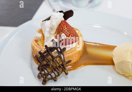 Dessert de haute cuisine recouvert de poussière d'or comestible. Pâte feuilletée à la crème brûlée, aux framboises et aux carreaux de chocolat, recouverte de vanille malgache Banque D'Images