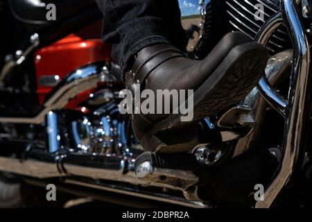 Moto. Vue du bas des jambes des bottes de cowboy en cuir Banque D'Images