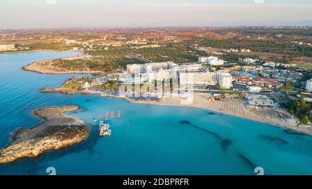 Vue panoramique sur la célèbre plage de Nissi, Ayia Napa, Famagusta, Chypre. L'attraction touristique touristique touristique célèbre baie d'îlots au lever du soleil avec or Banque D'Images