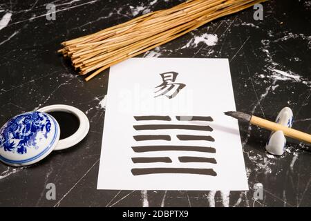 Gros plan d'un arrangement I Ching avec le 63ème hexagramme (après la complition/Chi Chi) écrit avec une brosse à encre chinoise sur papier de riz. Il y en a aussi Banque D'Images