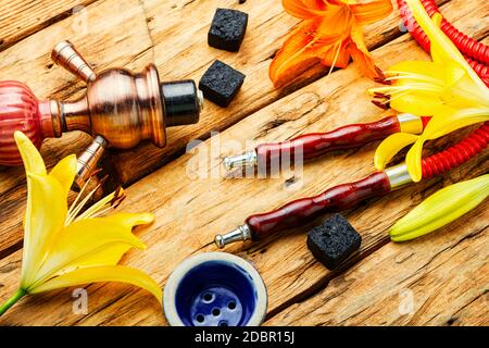 Narguilé asiatique fumant avec tabac à fleurs parfumé. Chicha au goût de Lily Banque D'Images