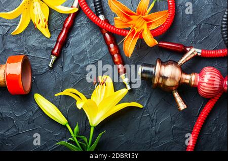 Narguilé asiatique fumant avec tabac à fleurs parfumé. Chicha au goût de Lily Banque D'Images