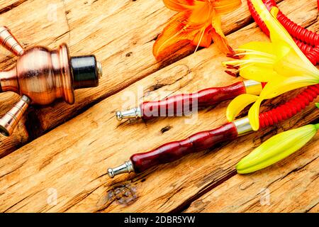 Narguilé asiatique fumant avec tabac à fleurs parfumé. Chicha au goût de Lily Banque D'Images