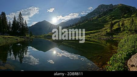 Les premiers rayons du soleil se reflètent dans le lac de montagne Banque D'Images