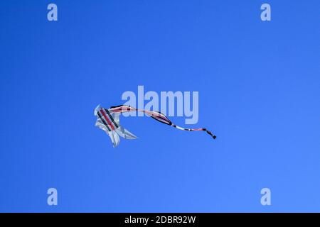 long tailleurs cerf-volant sur ciel bleu. Le cerf-volant coloré sur le ciel bleu sans nuages. Espace pour le texte. Banque D'Images