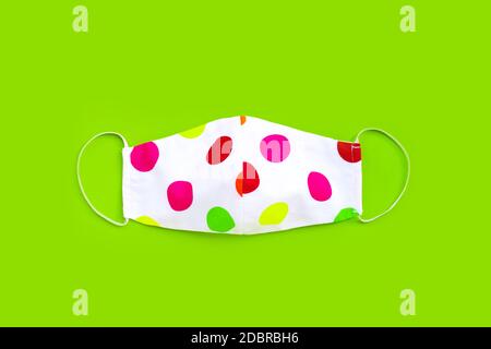 Masque en tissu coloré fait main sur fond vert. Vue de dessus Banque D'Images