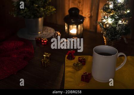 Une tasse de café sur la table avec un allumé Bougie et arbre de Noël Banque D'Images