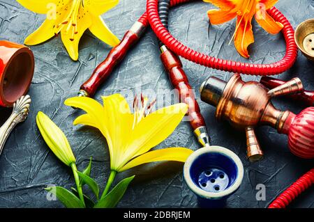 Narguilé asiatique fumant avec tabac à fleurs parfumé. Chicha au goût de Lily Banque D'Images