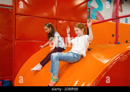 Les amies joueuses jouent parmi les cubes doux dans le centre de divertissement. Loisirs pour filles en vacances, bonheur d'enfance, enfants heureux sur l'aire de jeux Banque D'Images