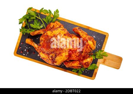 Poulet rôti entier sur plaque d'ardoise, plat, fond blanc Banque D'Images