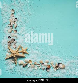 Sel de mer, coquillages et étoiles de mer sur fond turquoise. Flat lay, vue de dessus. Placer pour du texte ou des articles promotionnels. Banque D'Images