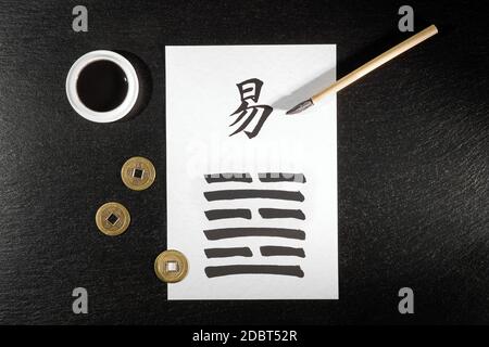 Gros plan d'un arrangement I Ching sur l'ardoise avec le 63ème hexagramme (après la complition/Chi Chi) écrit avec une brosse à encre chinoise sur du papier de riz. Là Banque D'Images