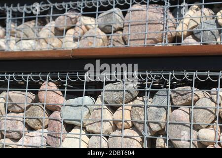 Mur de clôture de gabion en maille d'acier avec des pierres . Treillis métallique de gabion . Banque D'Images