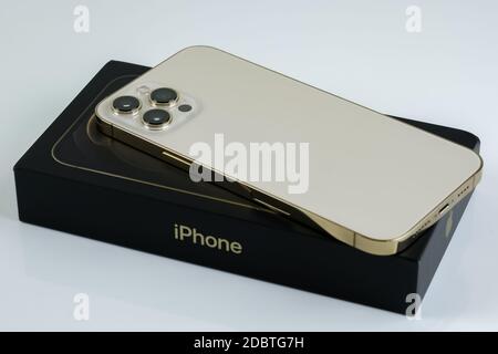 IPhone 12 Pro Max en or à côté de sa boîte. Banque D'Images