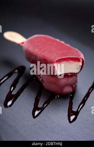 Le bâton de glace aux fruits semble frais à manger placé sur un fond noir. Banque D'Images