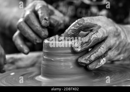 Les mains de potter. Le potter qui fait des plats de poterie sur tour de potier. Le sculpteur à l'atelier d'argile rend libre Banque D'Images