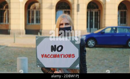 Jeune femme protestant contre la vaccination. Elle a porté un masque de protection et elle a marché dans la rue Banque D'Images