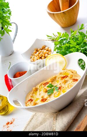 pâte de houmous avec citron et piment sur fond blanc Banque D'Images