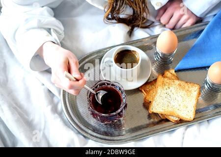 Petit déjeuner au lit dans l'hôtel. Après avoir pris la douche, un petit déjeuner est servi dans la chambre d'hôtel. Banque D'Images