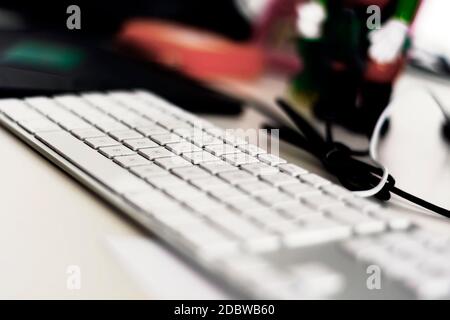 un clavier d'ordinateur gris moderne avec des touches blanches sur une table de bureau. Faible profondeur de champ. Profession et travail de bureau Banque D'Images