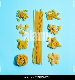 Pâtes concent. Types de pâtes différents sur fond bleu. Concept de guide des pâtes avec mise en page créative. La nourriture est un pas. Art. Pâtes. Vue sur le dessus ou sur une surface plane. Banque D'Images