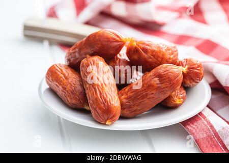 Mini saucisses salami sur une assiette sur table blanche. Banque D'Images