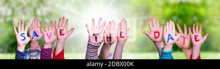 Enfants mains construire coloré Anglais Word Enregistrer la date. Vert prairie ensoleillé comme arrière-plan Banque D'Images