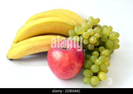 Grosse pomme rouge devant le bouquet de bananes et raisin vert indien mûr isolé sur fond blanc Banque D'Images